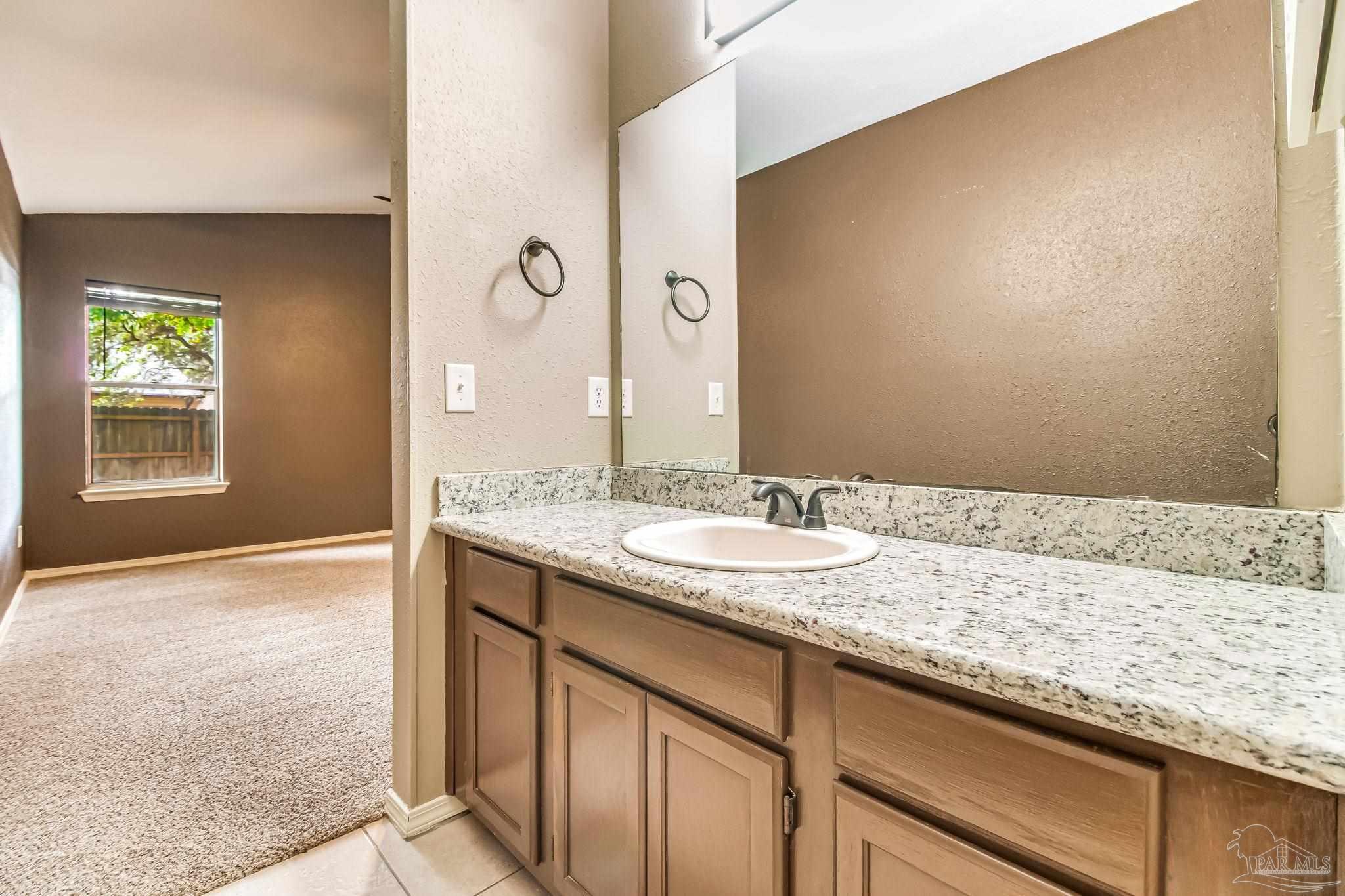 4554 Northpointe Place Pensacola, FL 32514 - Photo 14 of 42 a bathroom with a granite countertop sink and a mirror