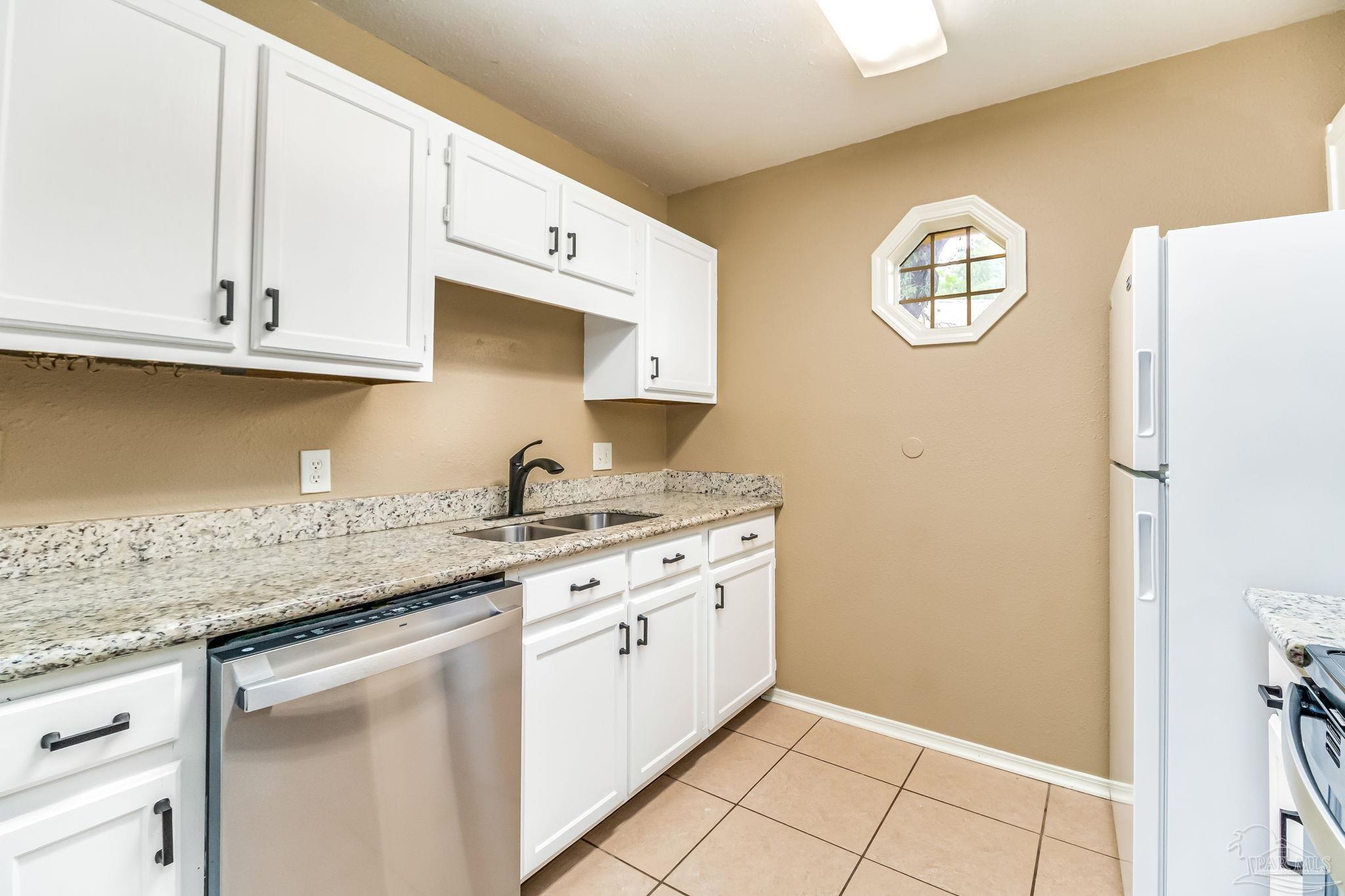 4554 Northpointe Place Pensacola, FL 32514 - Photo 20 of 42 a kitchen with granite countertop white cabinets white stainless steel appliances and a sink