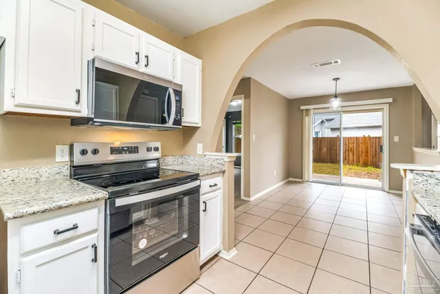 a kitchen with stainless steel appliances granite countertop a stove a microwave and a sink