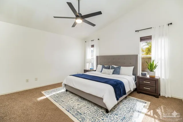 an empty room with windows and ceiling fan
