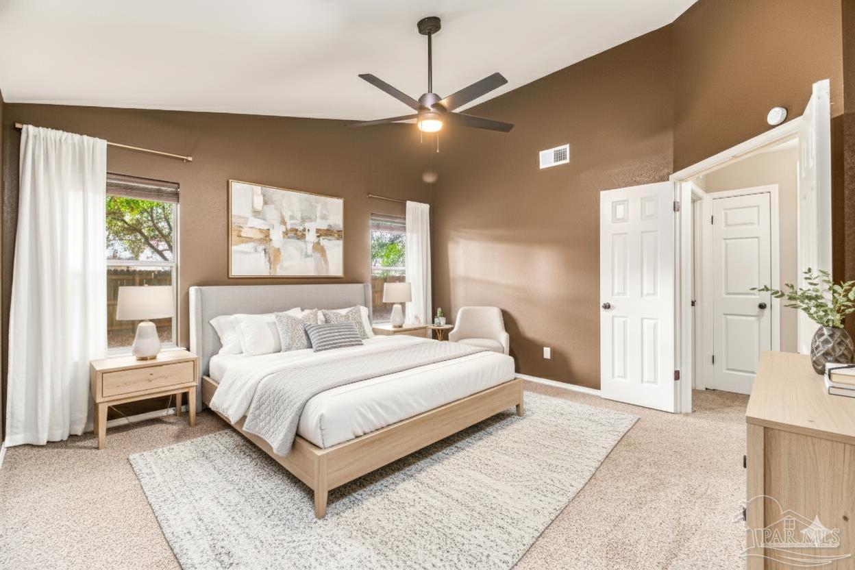 4554 Northpointe Place Pensacola, FL 32514 - Photo 8 of 42 a bedroom with a large bed chandelier and a window