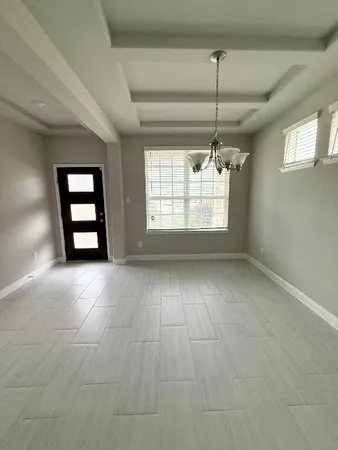 an empty room with windows and ceiling fan