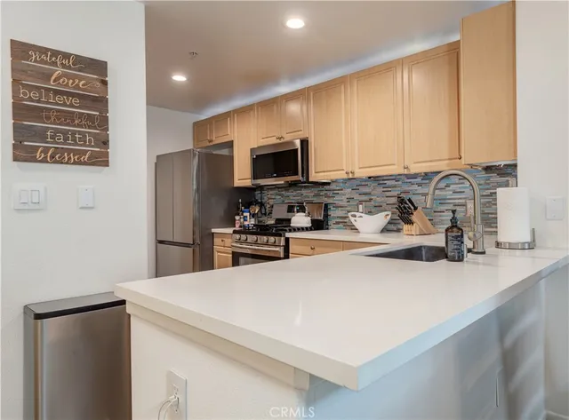 a kitchen with stainless steel appliances a refrigerator sink and microwave