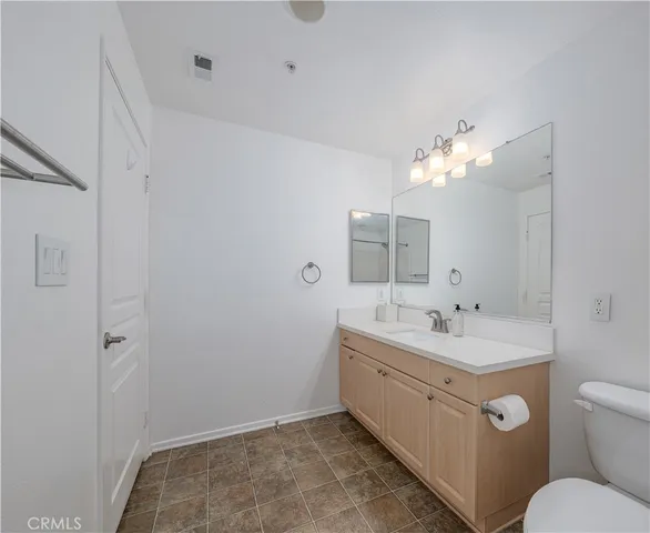 a bathroom with a sink a toilet and a mirror