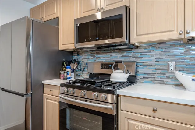 a kitchen with stainless steel appliances granite countertop a stove microwave and refrigerator