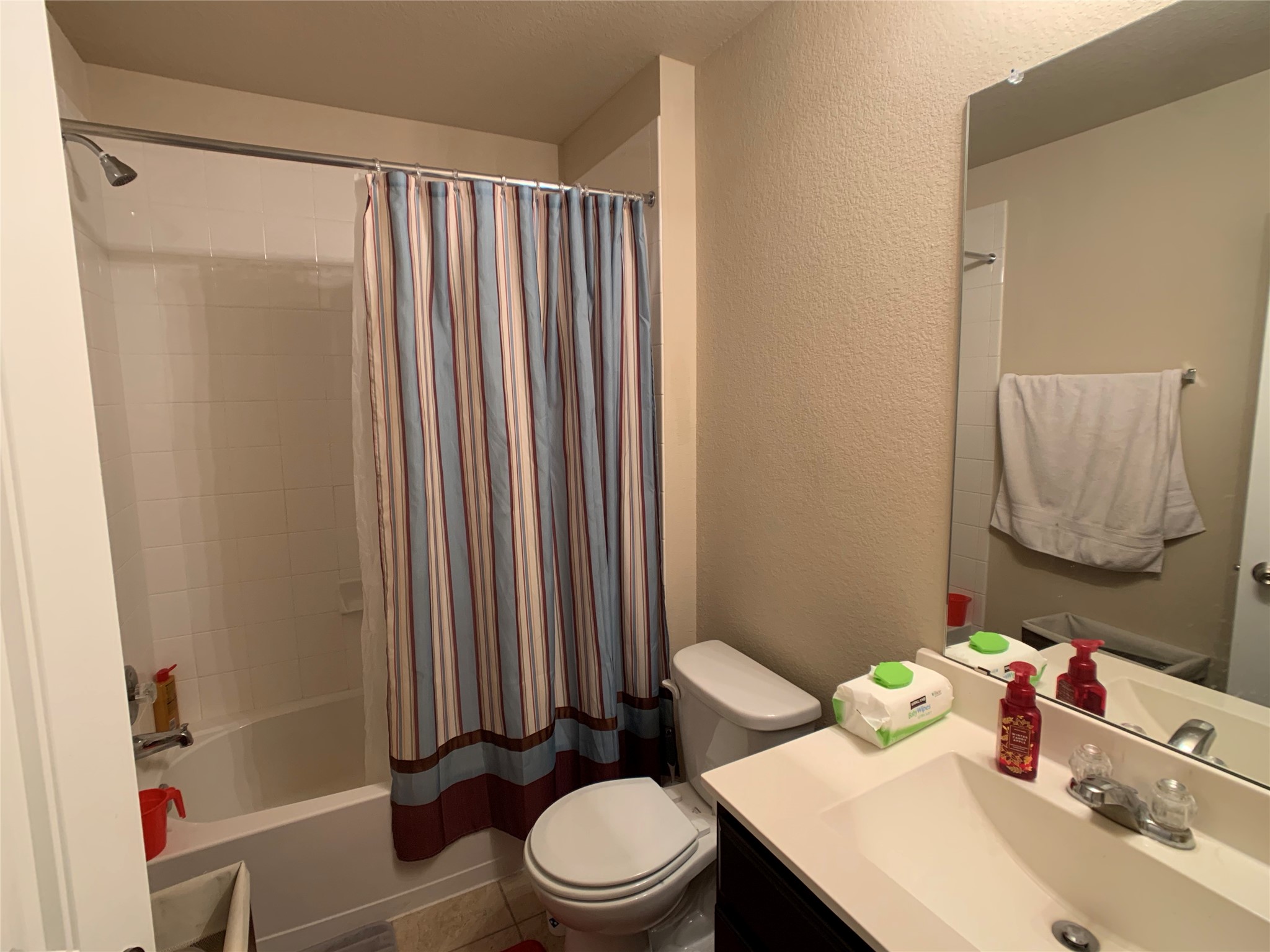 5721 Roderick Drive Austin, TX 78724 - Photo 11 of 26 Bathroom featuring a textured wall, vanity, and shower / bath combo with shower curtain