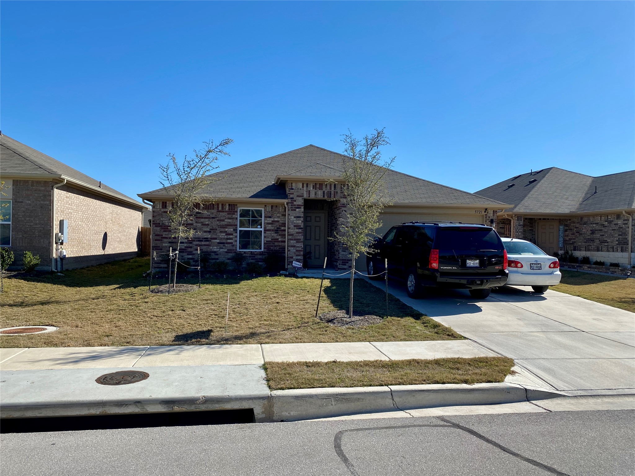 5721 Roderick Drive Austin, TX 78724 - Photo 2 of 26 Ranch-style house with a front yard, a garage, concrete driveway, and brick siding