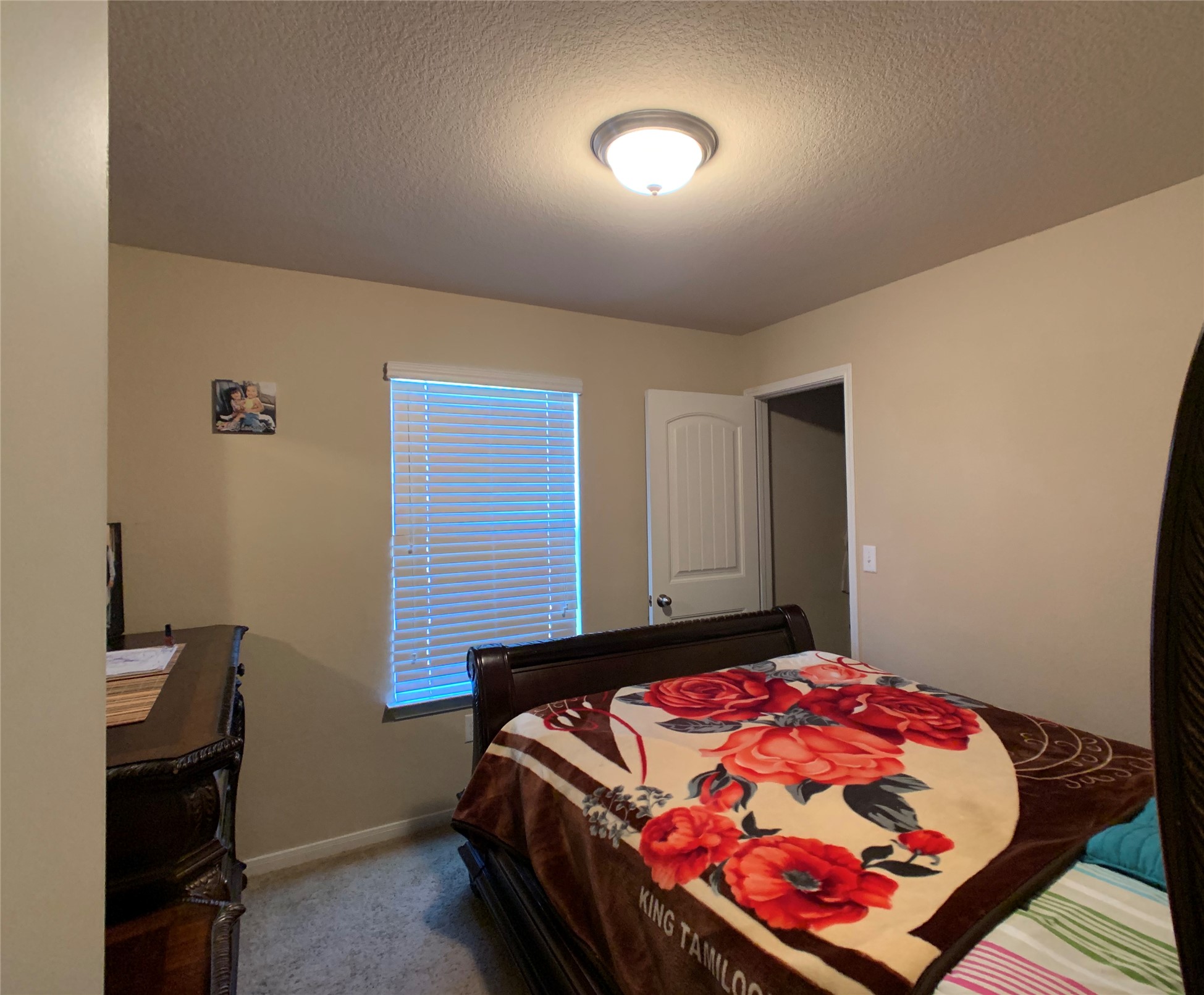 5721 Roderick Drive Austin, TX 78724 - Photo 9 of 26 Bedroom featuring light colored carpet and a textured ceiling