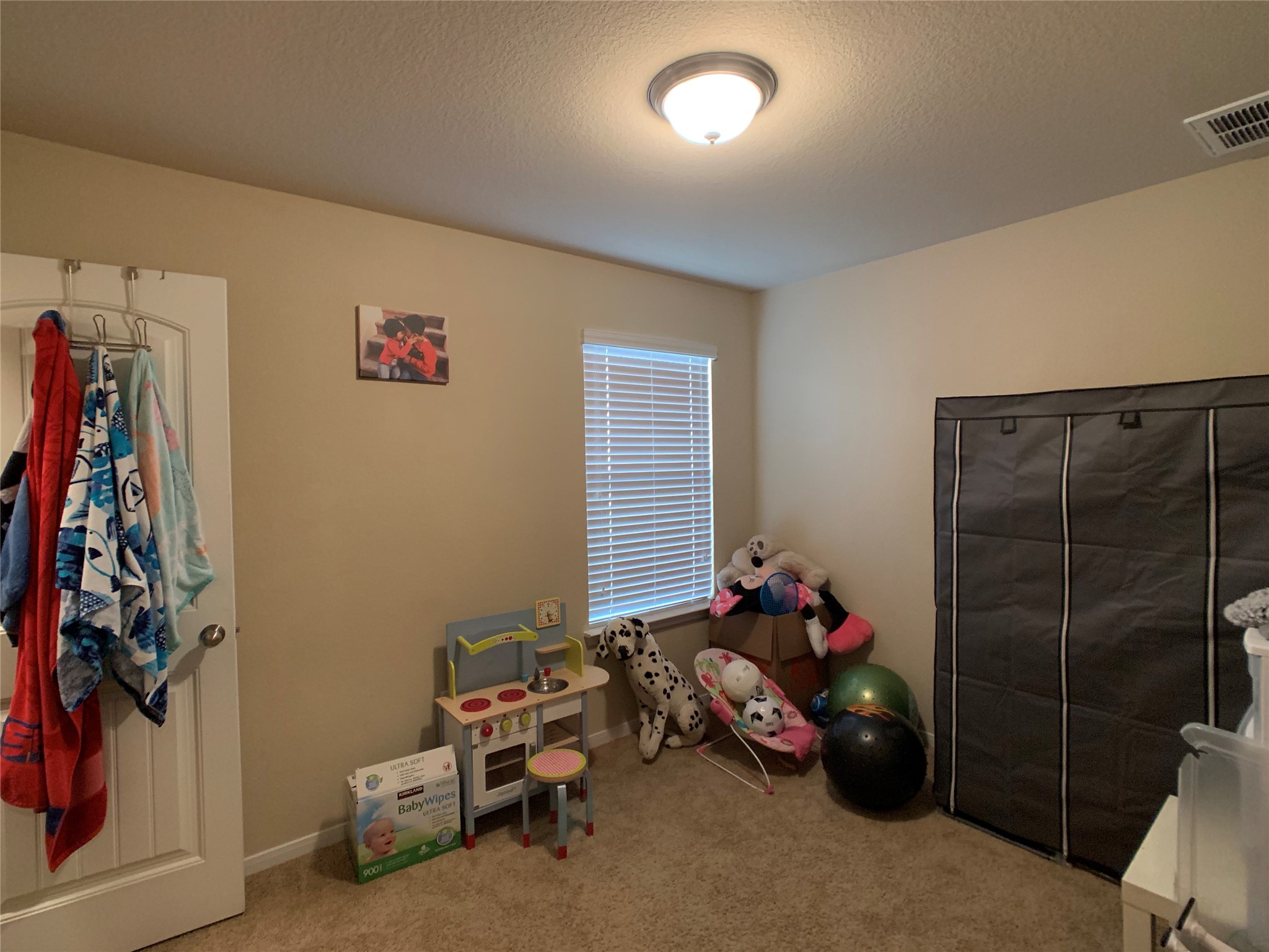 5721 Roderick Drive Austin, TX 78724 - Photo 10 of 26 Recreation room featuring light carpet and a textured ceiling