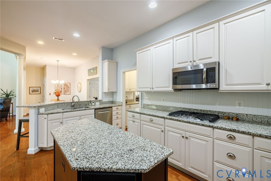 704 Chiswick Park Road Henrico, VA 23229 - Photo 17 of 47 a kitchen with stainless steel appliances granite countertop a stove top oven a sink dishwasher and white cabinets with wooden floor
