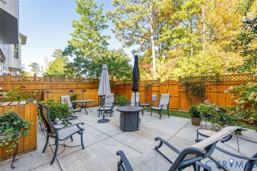 704 Chiswick Park Road Henrico, VA 23229 - Photo 35 of 47 a view of a patio with couches and table and chairs under an umbrella