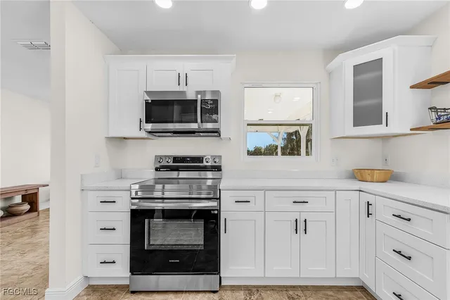 a kitchen with white cabinets and stainless steel appliances