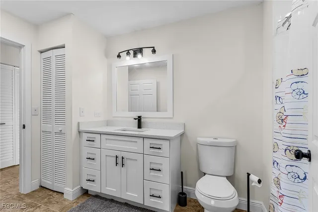 a bathroom with a toilet a sink a vanity and mirror