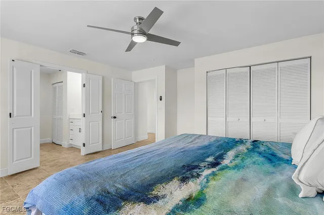 a bedroom with a large bed and a chandelier