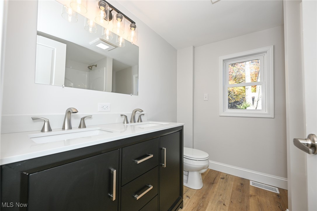 14328 Calaboone Road Doylestown, OH 44230 - Photo 19 of 45 Bathroom featuring light wood-type flooring, double vanity, and a shower