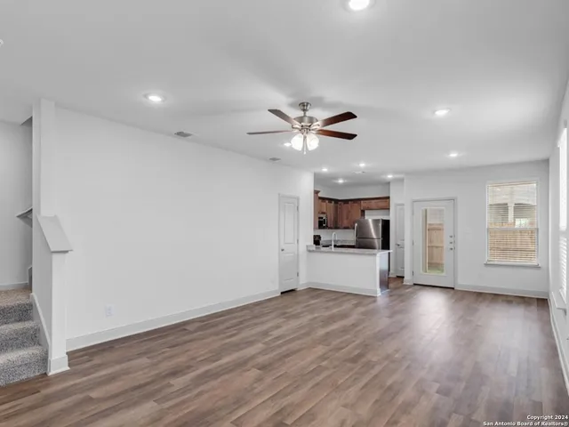 a view of an empty room with window and wooden floor