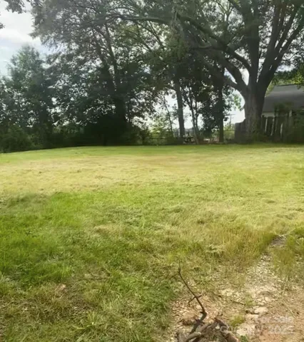 a view of yard with swimming pool and trees