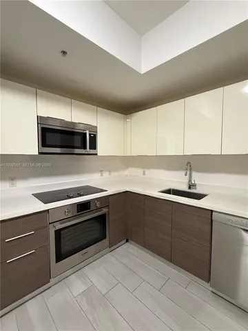 a kitchen with sink a microwave a stove and cabinets