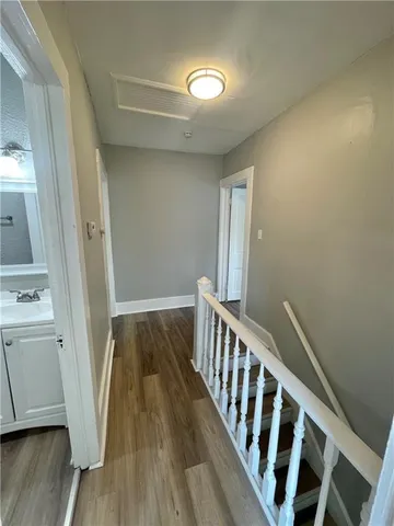 a view of a hallway with wooden floor and staircase
