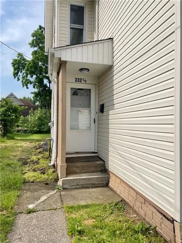 a view of small house with a yard and potted plants