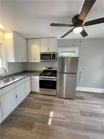 a kitchen with a refrigerator cabinets and wooden floor