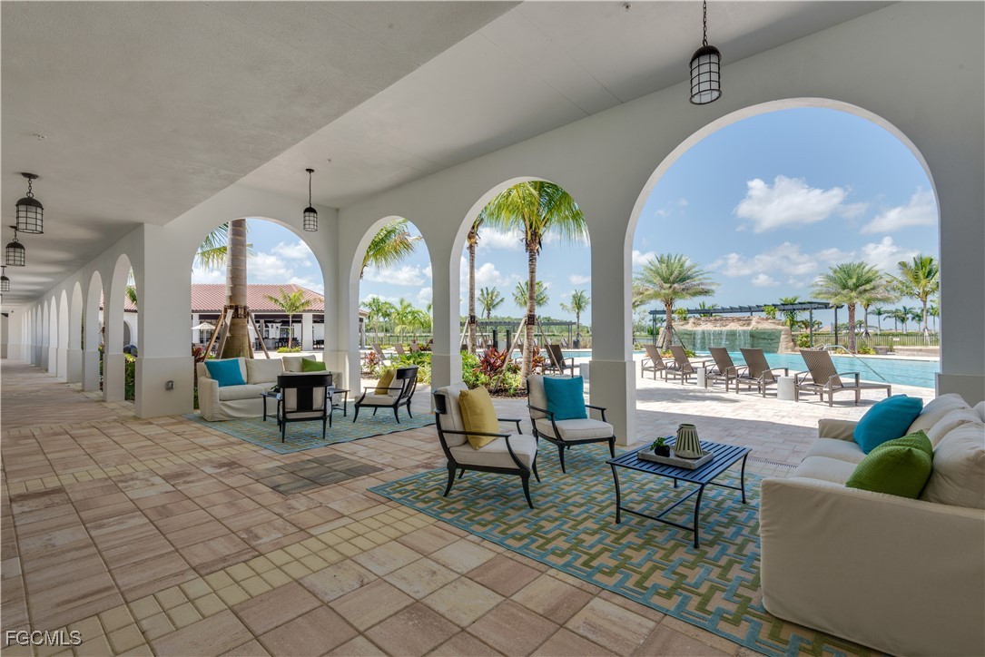 11768 Grand Belvedere Way, Unit 203 Fort Myers, FL 33913 - Photo 34 of 47 a living room with couches and a dining table with garden view