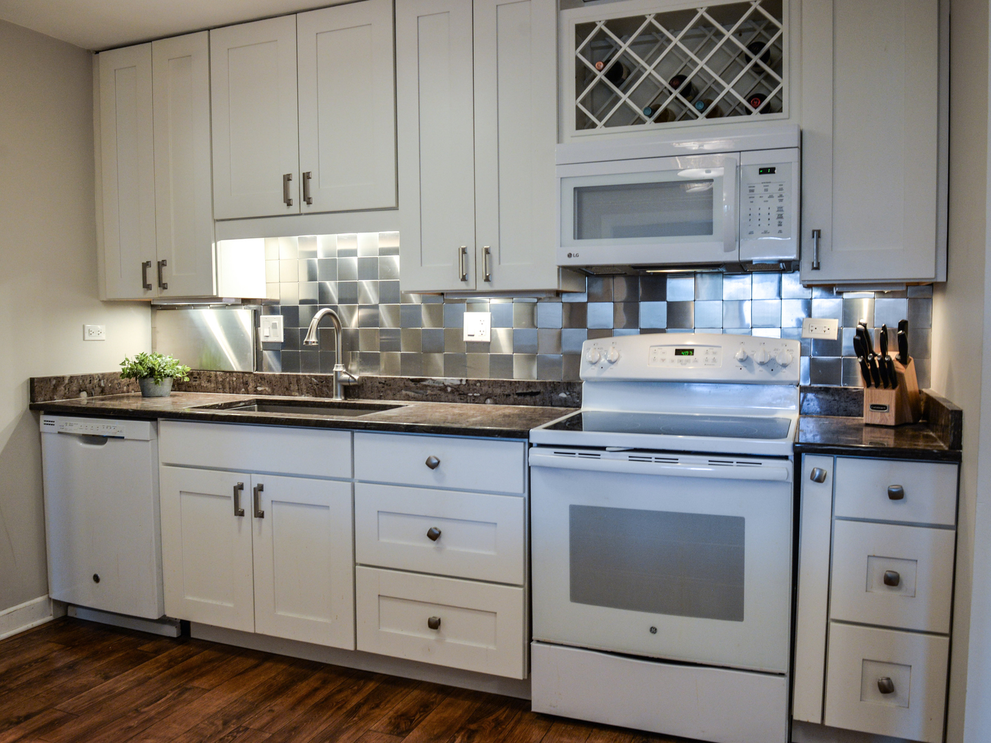 1605 East Central Road, Unit 203A Arlington Heights, IL 60005 - Photo 5 of 11 a kitchen with granite countertop white cabinets and white appliances