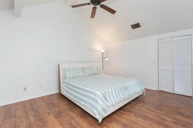 a bedroom with a bed and painting on the wall