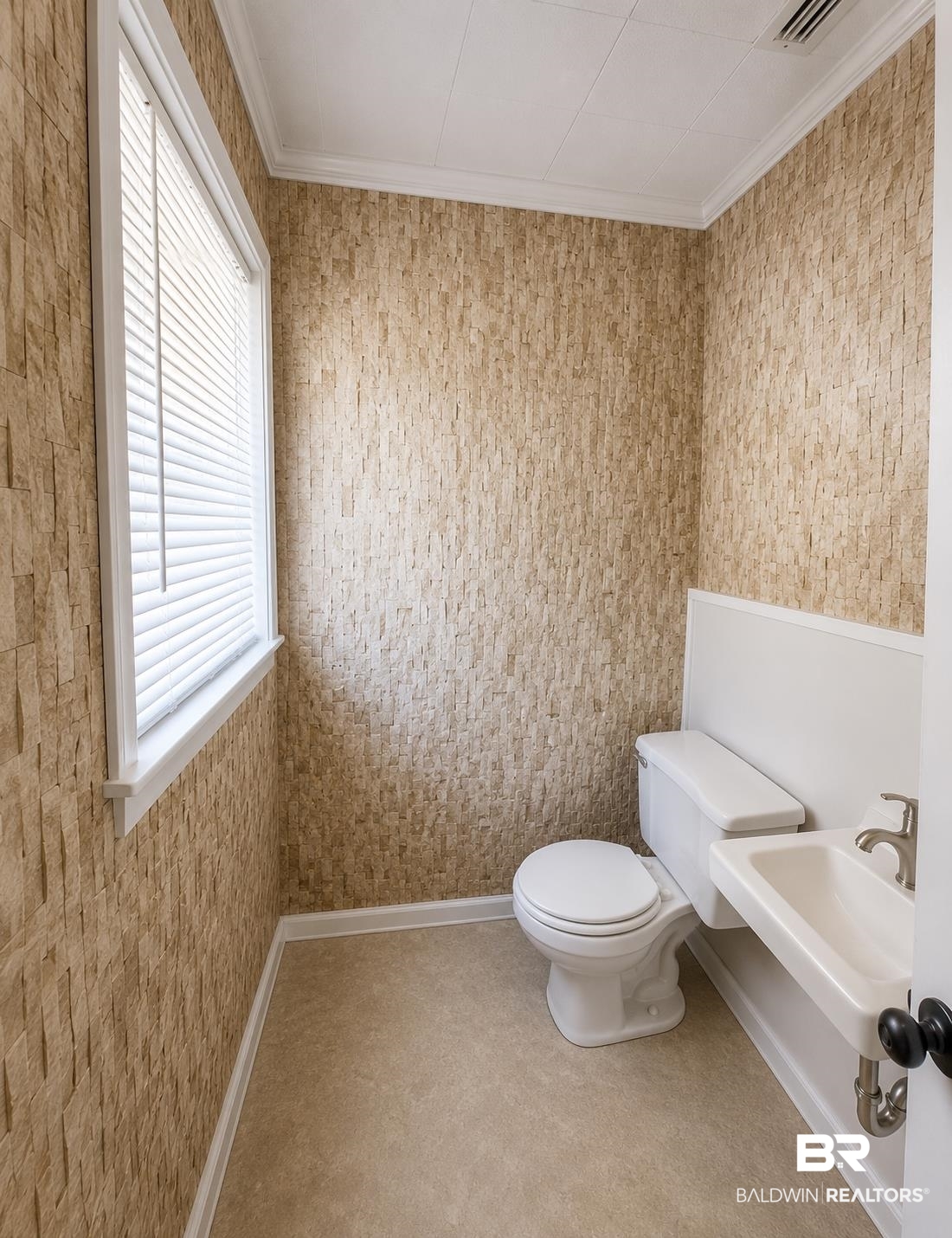 226 Elizabeth Street Evergreen, AL 36401 - Photo 21 of 35 Powder room featuring textured wall covering, a compact wall-mounted sink with brushed nickel faucet, a white toilet, and window with blinds