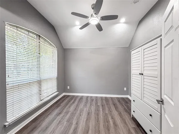 an empty room with wooden floor and window