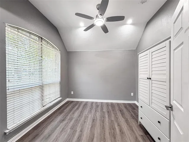 an empty room with wooden floor and window