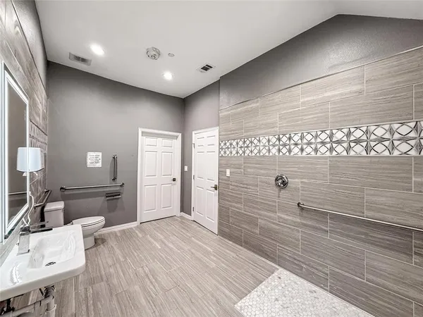 a bathroom with a toilet a sink and mirror