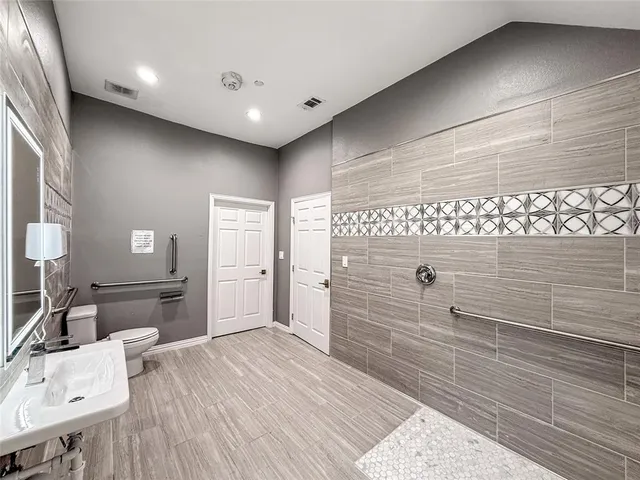 a bathroom with a toilet a sink and mirror