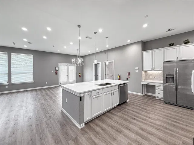 a large kitchen with a lot of counter space and a wooden floor