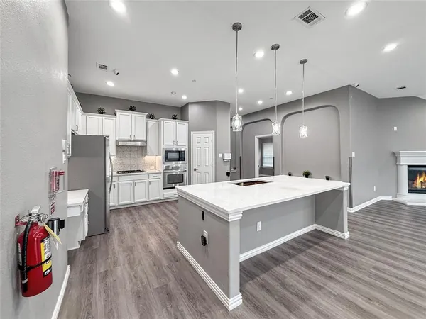 a large kitchen with kitchen island a stove a sink a refrigerator and a refrigerator