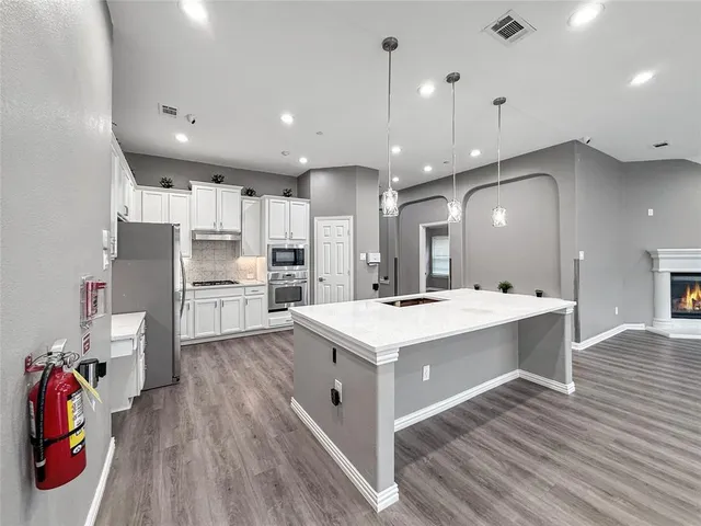 a large kitchen with kitchen island a stove a sink a refrigerator and a refrigerator