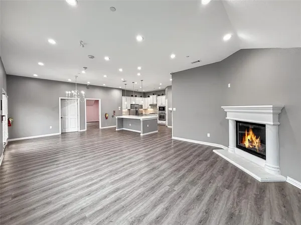 a kitchen with cabinets stainless steel appliances and wooden floor