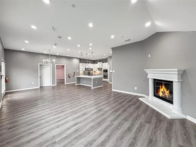 a kitchen with cabinets stainless steel appliances and wooden floor