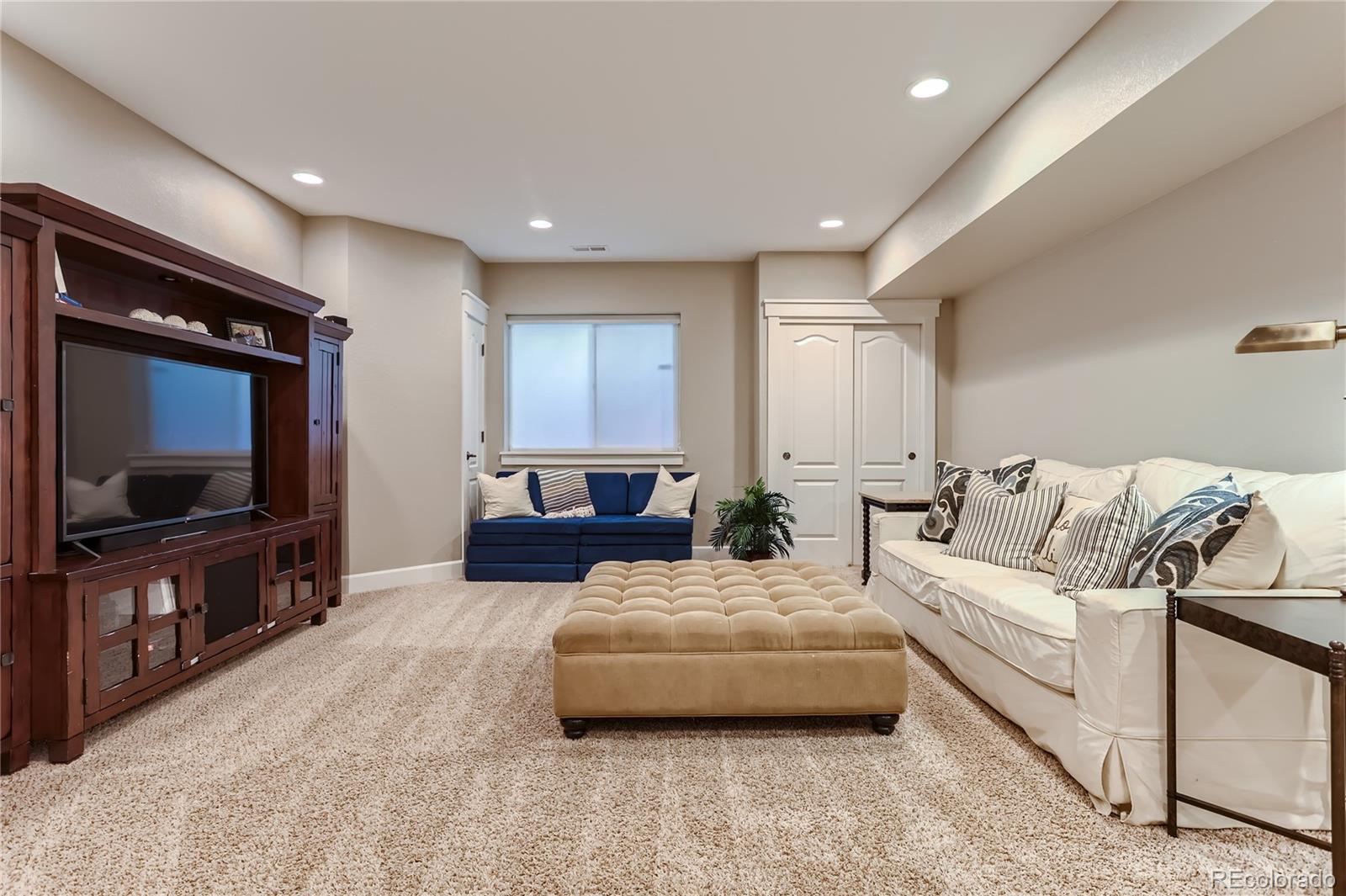 908 Syracuse Street Denver, CO 80230 - Photo 16 of 28 a living room with furniture and a flat screen tv