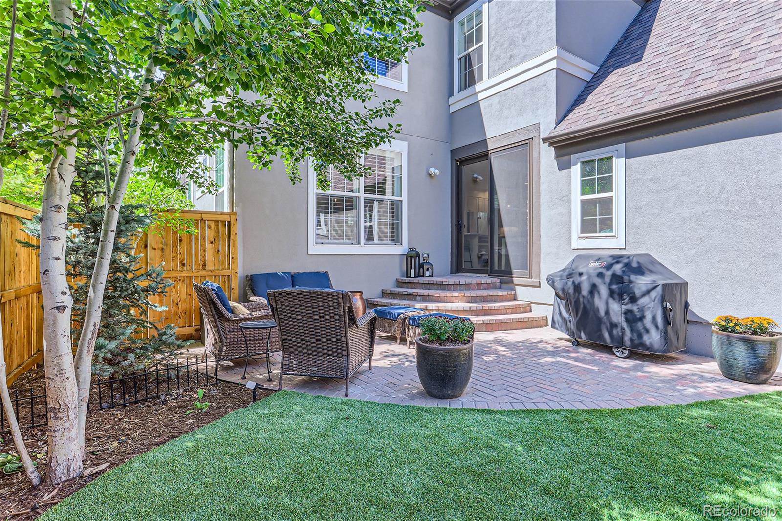 908 Syracuse Street Denver, CO 80230 - Photo 18 of 28 a view of a house with patio and a garden