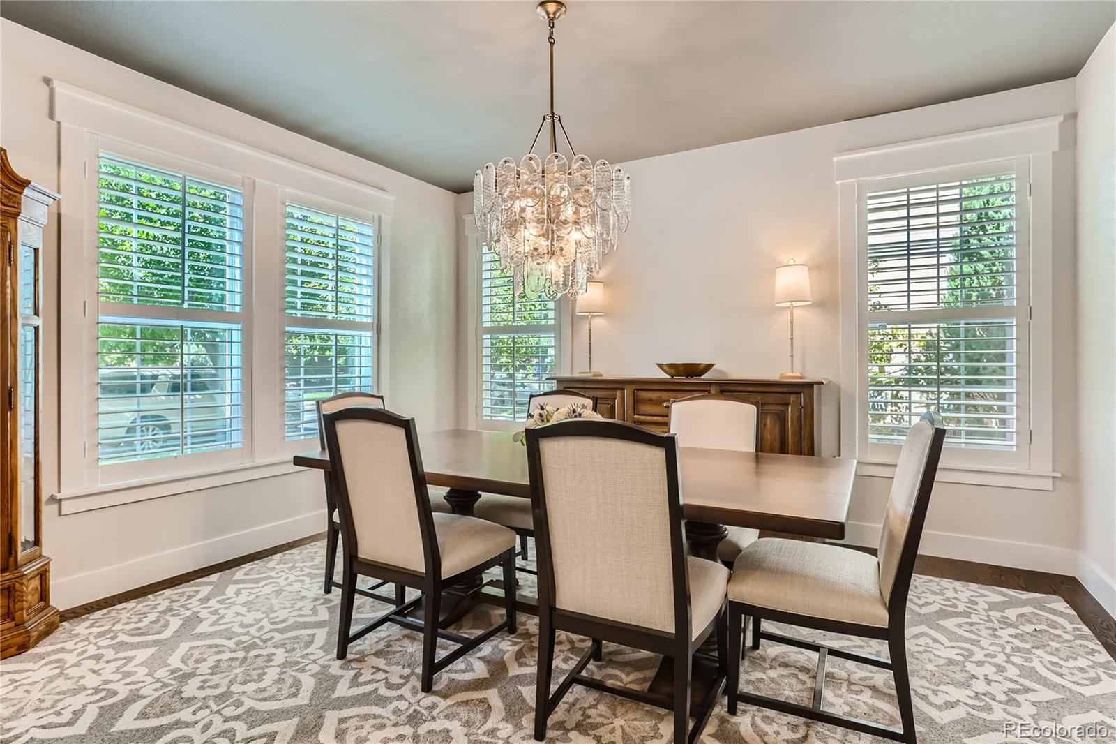 908 Syracuse Street Denver, CO 80230 - Photo 2 of 28 a dining room with furniture a chandelier and wooden floor