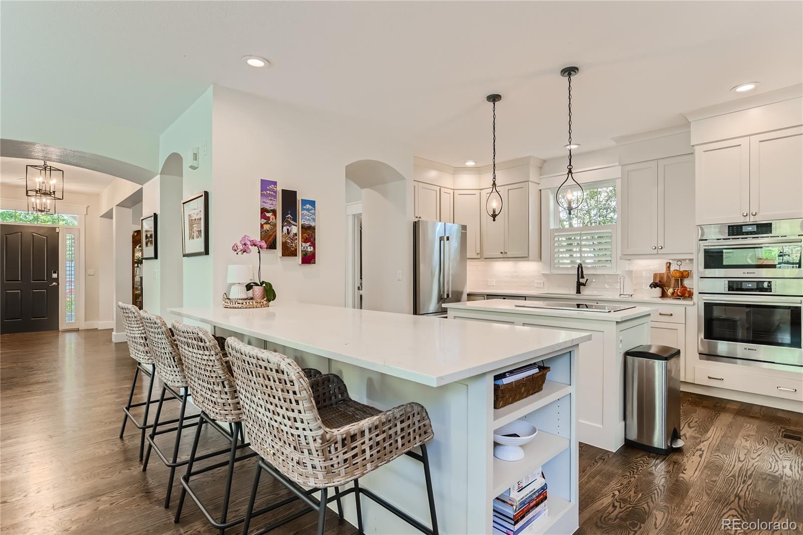 908 Syracuse Street Denver, CO 80230 - Photo 6 of 28 a kitchen with stainless steel appliances a stove a sink a dining table and chairs