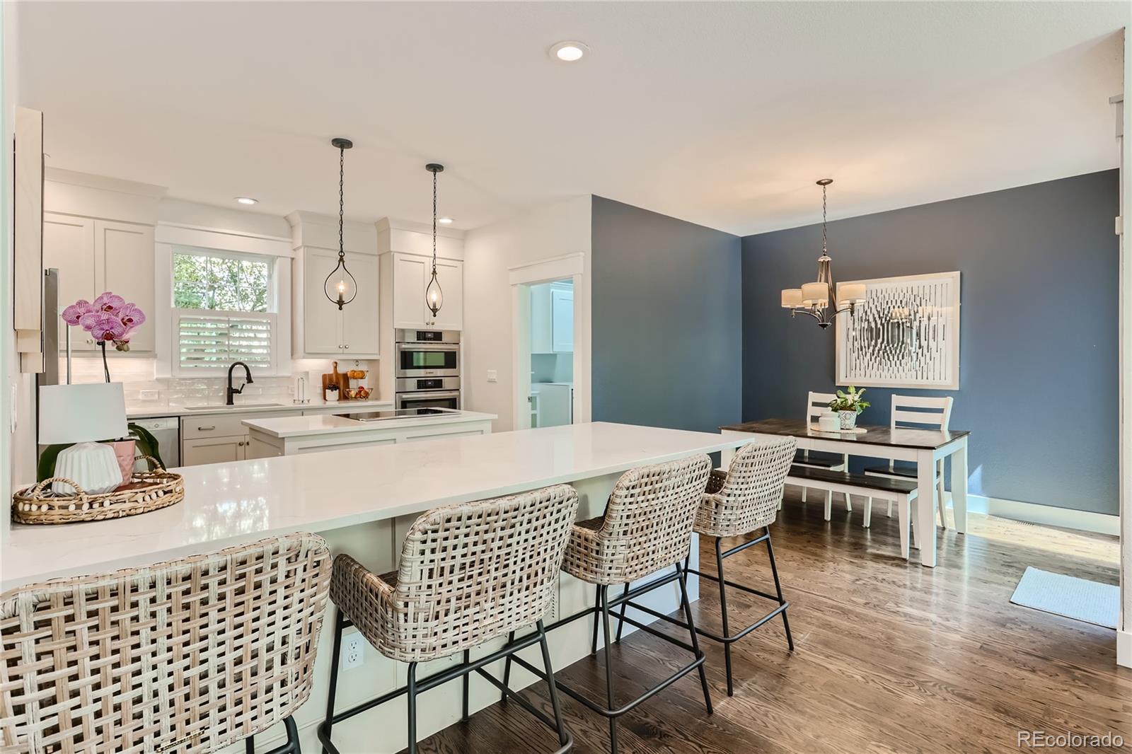 908 Syracuse Street Denver, CO 80230 - Photo 7 of 28 a kitchen with a dining table chairs and white cabinets