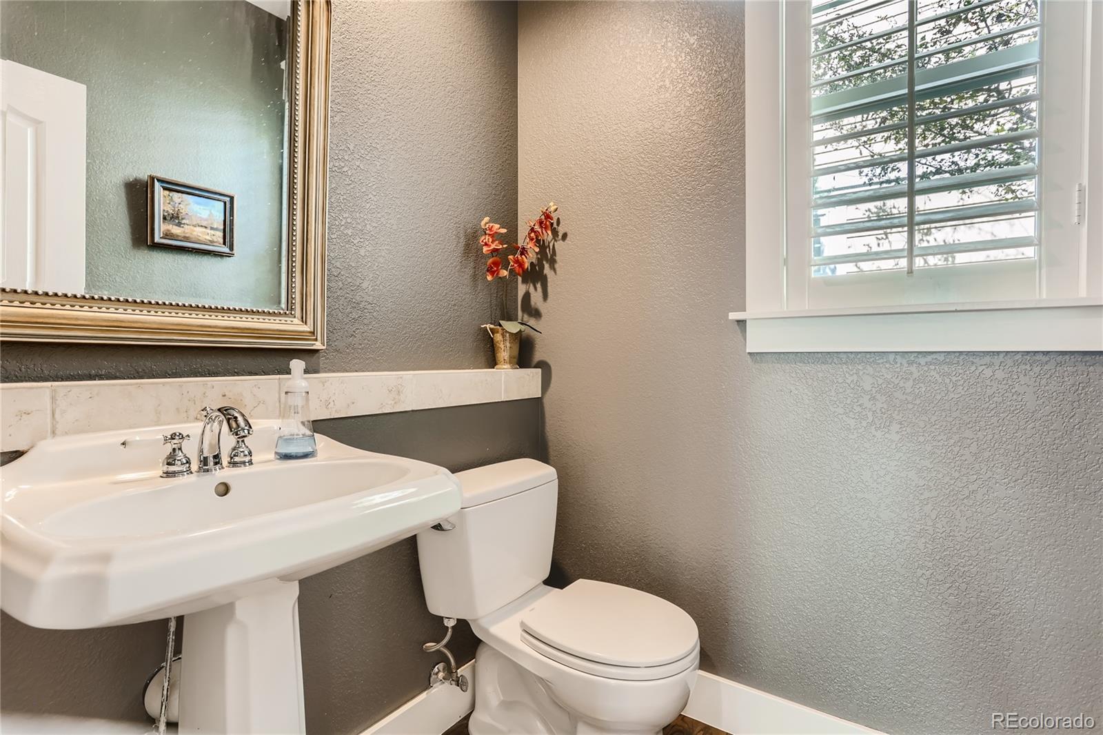 908 Syracuse Street Denver, CO 80230 - Photo 8 of 28 a bathroom with a sink mirror and toilet