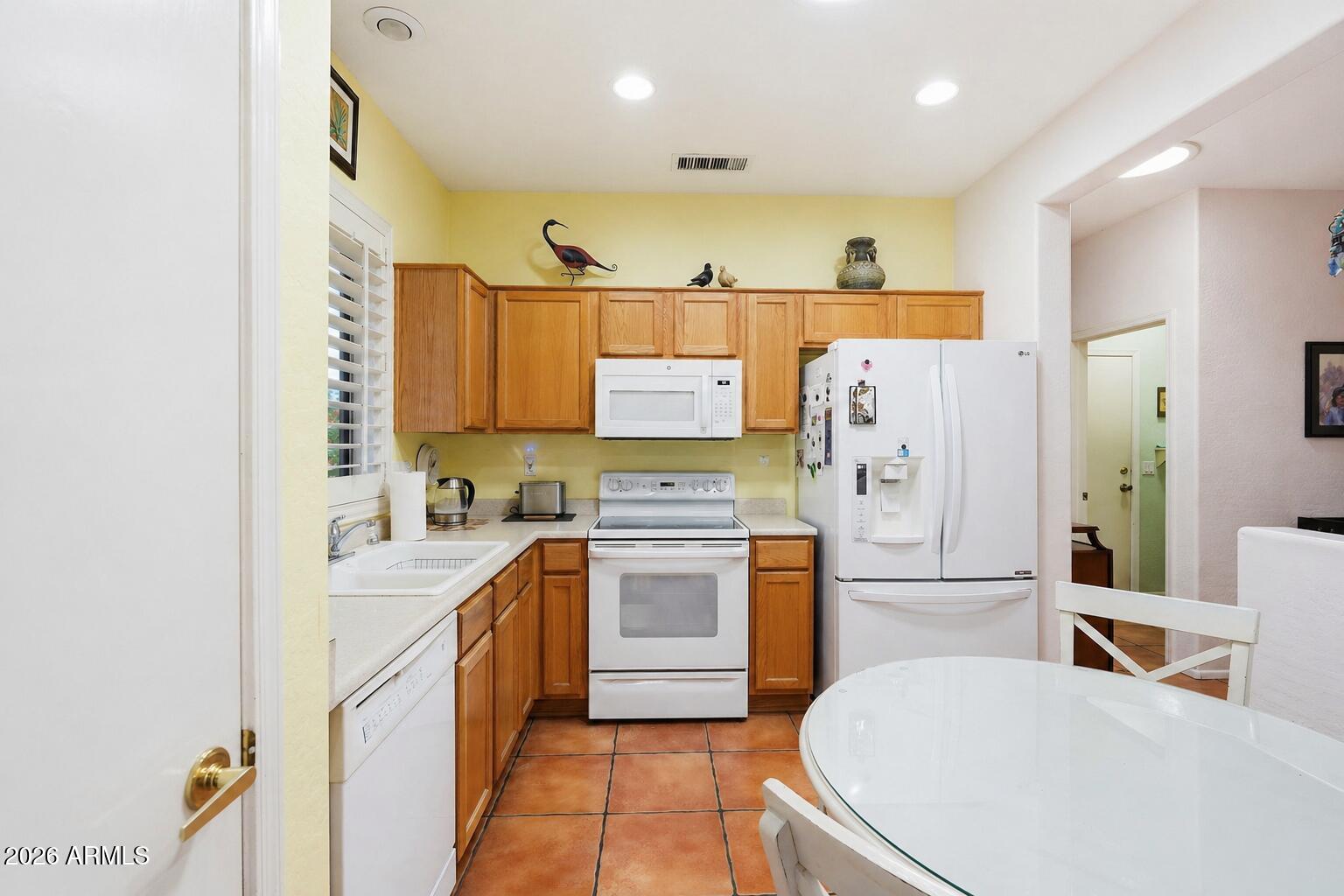 19113 North Hunters Run Surprise, AZ 85387 - Photo 7 of 45 a kitchen with stainless steel appliances a stove a sink and a refrigerator