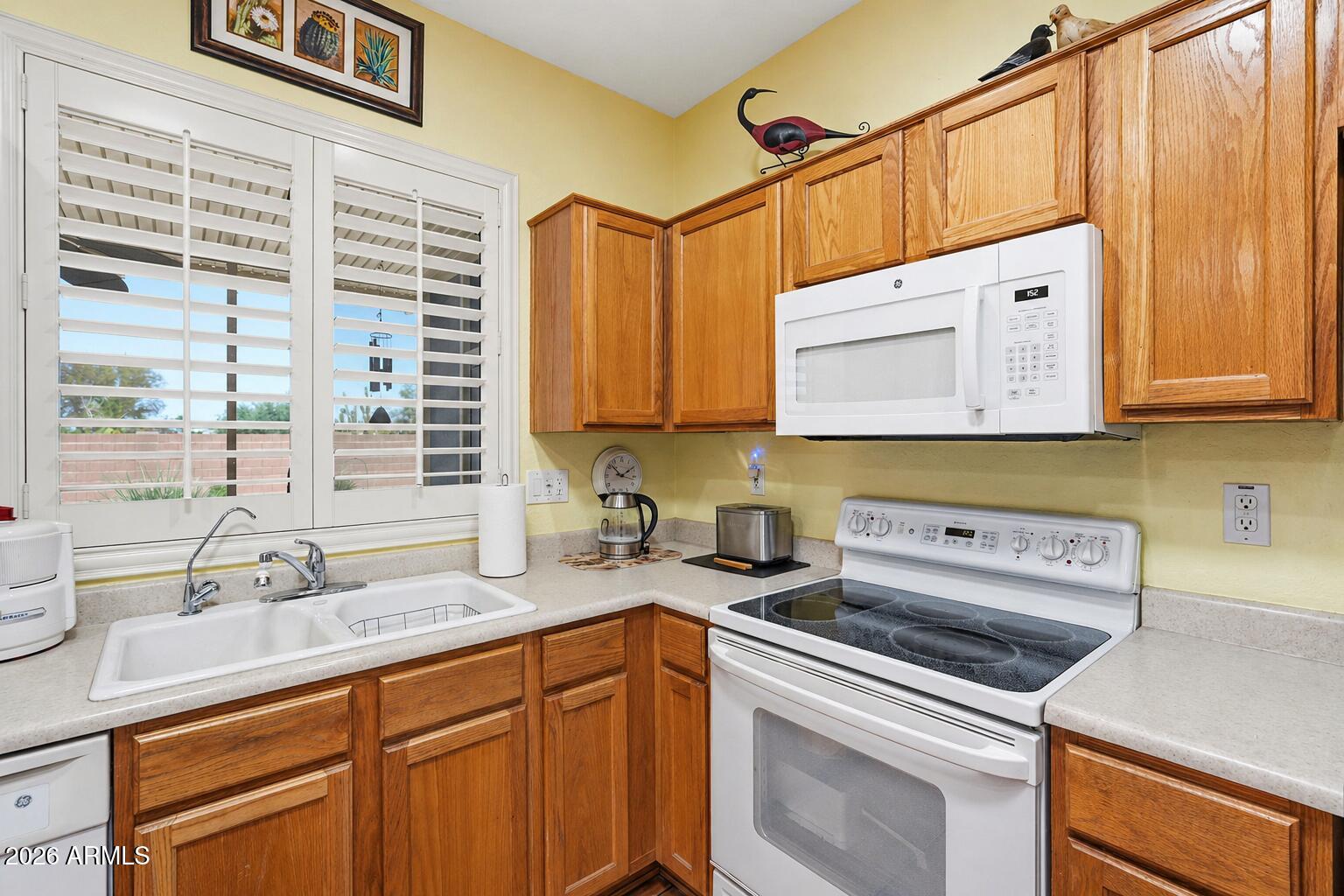 19113 North Hunters Run Surprise, AZ 85387 - Photo 8 of 45 a kitchen with stainless steel appliances a sink a stove and cabinets