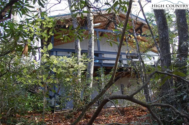 a view of a wooden house with a tree