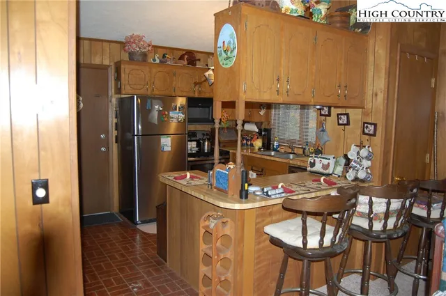 a kitchen with stainless steel appliances kitchen island granite countertop a refrigerator a stove and a microwave