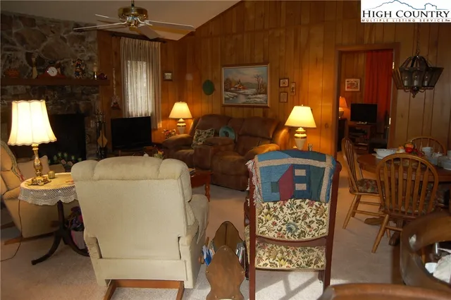 a living room with furniture a lamp and large window