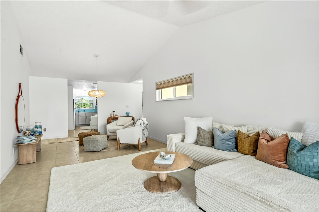 475 Grove Isle Circle, Unit 475 Vero Beach, FL 32962 - Photo 11 of 36 a living room with furniture and a lamp